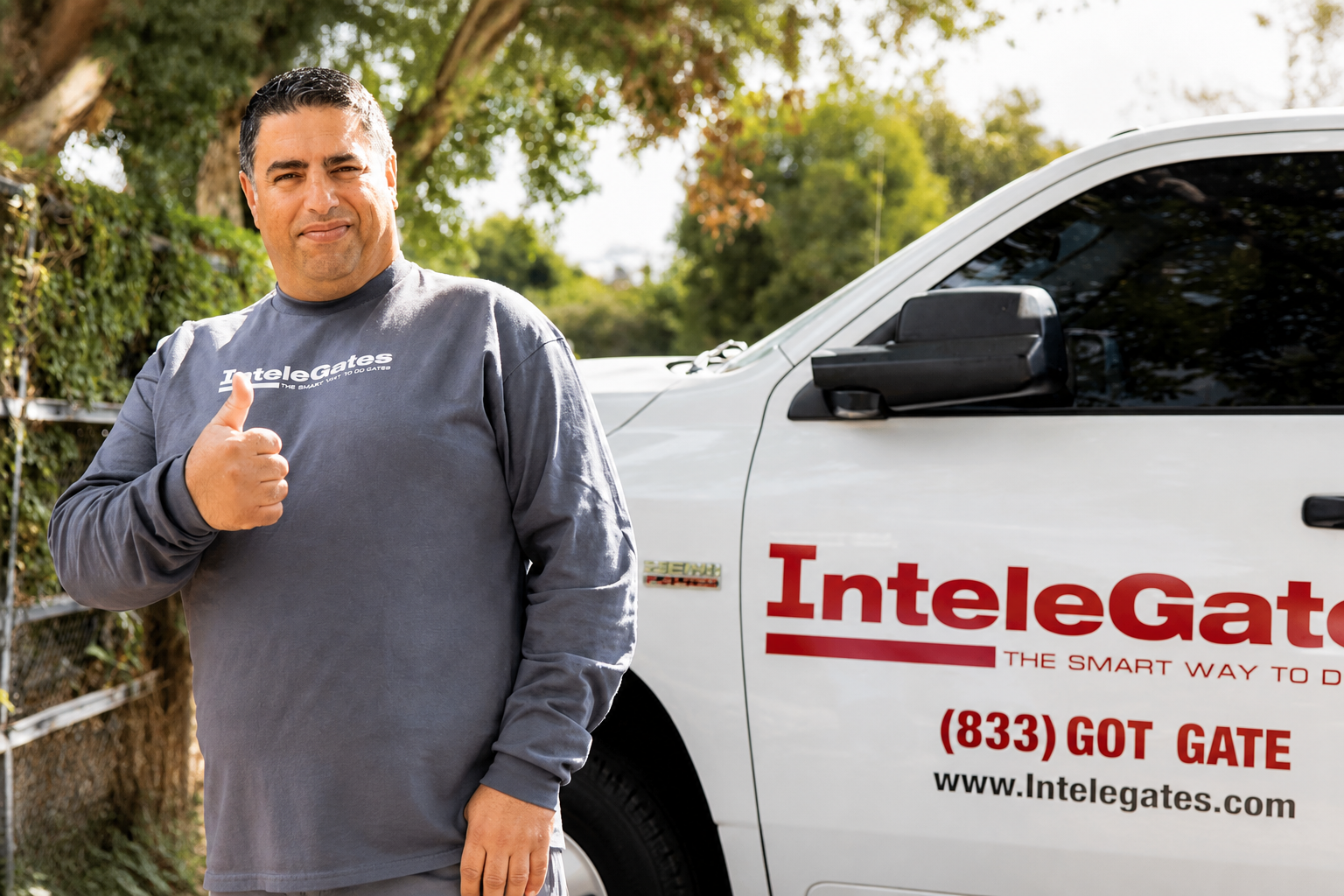 Ron from InteleGates giving a friendly thumbs-up beside the branded InteleGates service truck