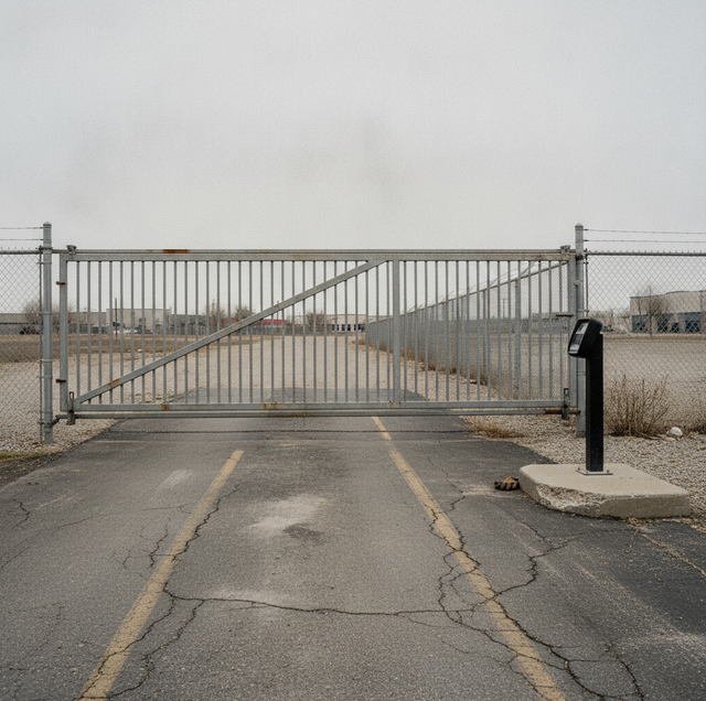 silver barrier arm and sliding gate at parking entrance driveway